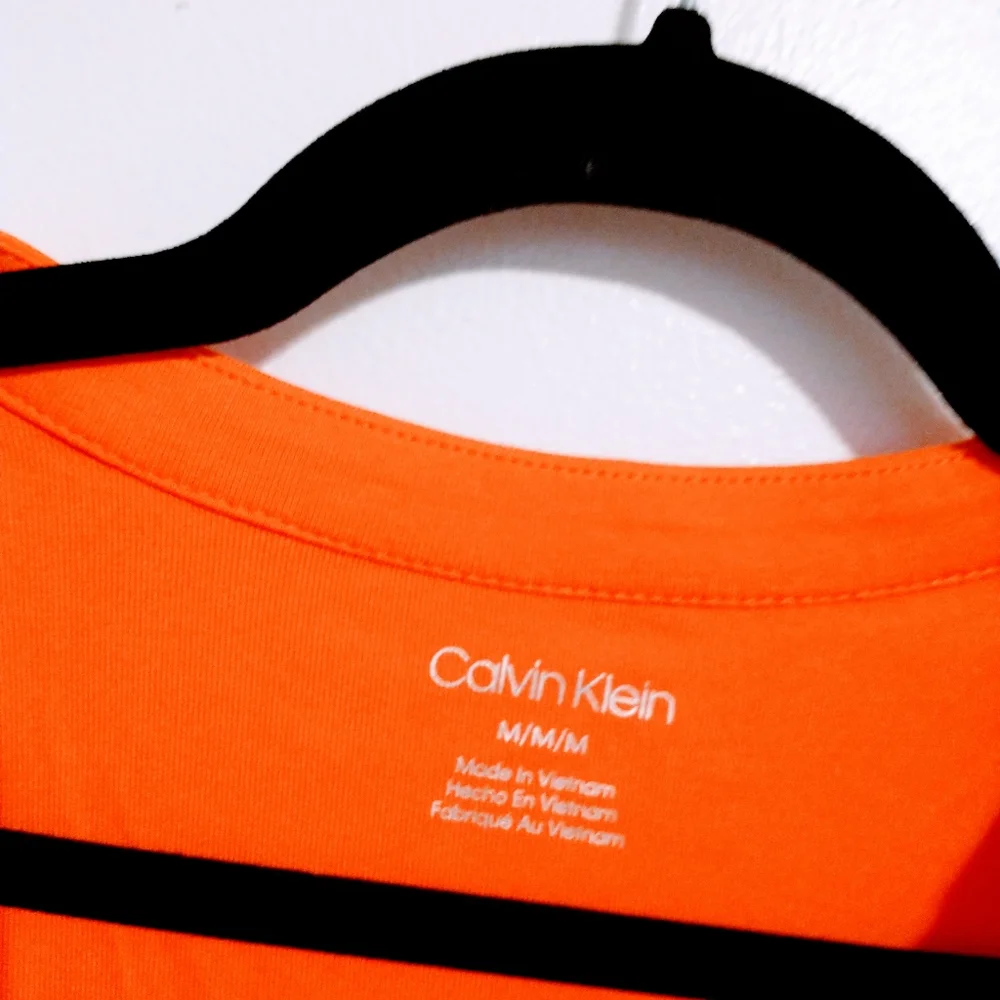 NWOT Calvin Klein orange short sleeve top with half button front detail.  Size